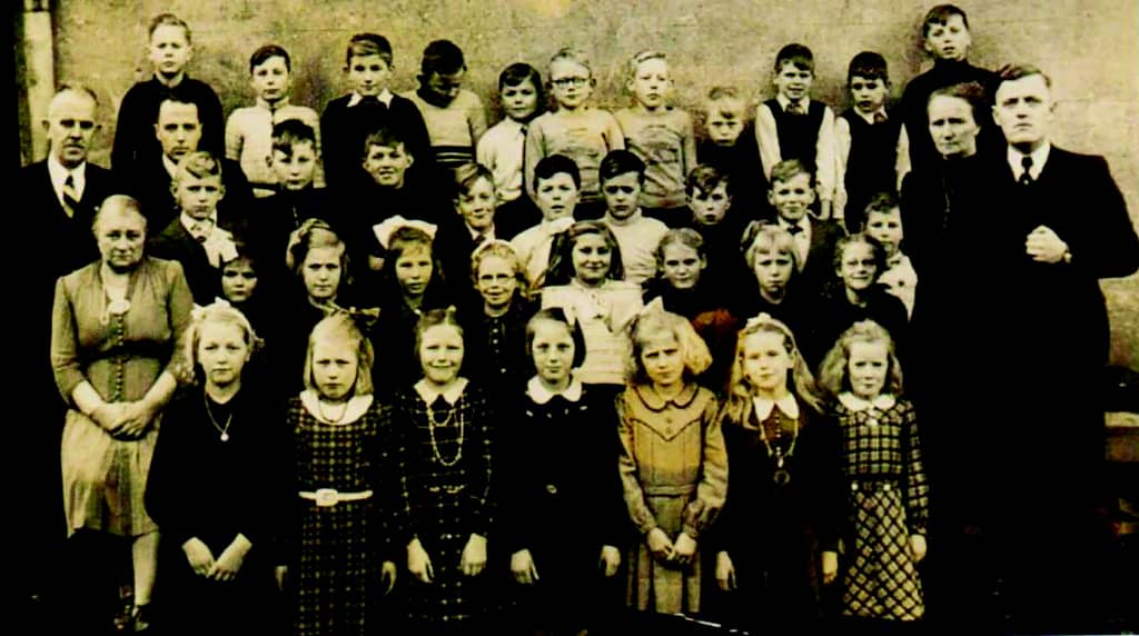 Kinderen op de School met de Bijbel. links: het hoofd van de school, meester Pruiksma, en uiterst rechts Joseefs leraar, meester Corporaal.
