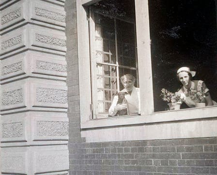 Directrice Henriëtte Pimentel (met haar onafscheidelijke hondje Brunie) en onderdirectrice juffrouwBurghoorn in het raam van de crèche aan de Plantage Middenlaan in Amsterdam, ca. 1942. Beeld: Collectie Joods Museum, Amsterdam