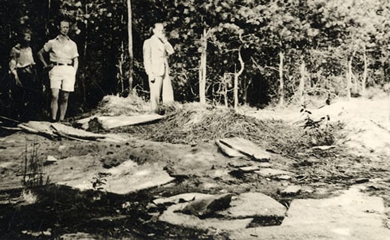 De restanten van de toegangshut tot een ondergrondse schuilplaats op de Veluwe, Nederland.De hut werd in laat 1944 door de Duitsers ontdekt en afgebroken. Links op de foto staat Harry Meyer. Beeld: Ghetto Fighters House Archives